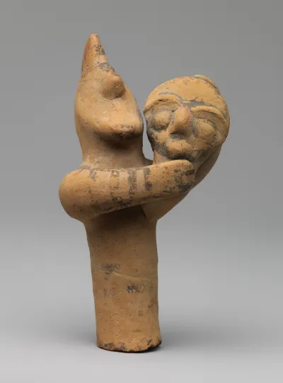 Terracotta statuette of a male figure holding the head and neck of a mask or image