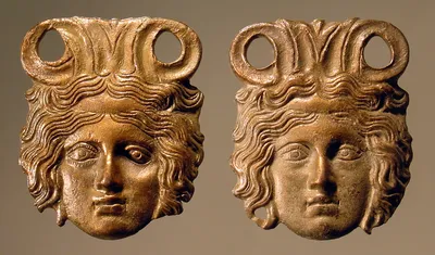 Attaschenpaar mit weiblichen Köpfen in flachem Relief