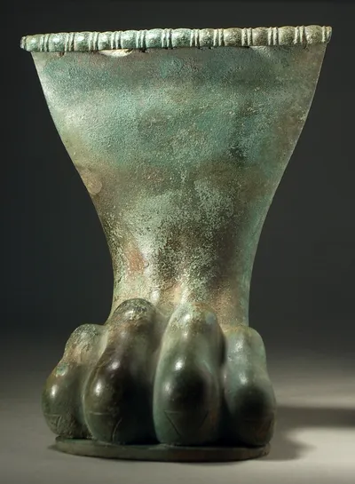 Löwenfuß, von einem Gerät, Patina, intakt, ovale Standplatte angelötet, oben Profil mit zwei unregelmäßigen Löchern (Gussfehler?), hinten große Öffnung