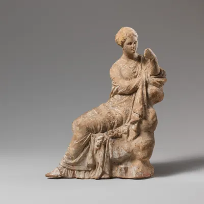 Terracotta statuette of a woman seated on a rock