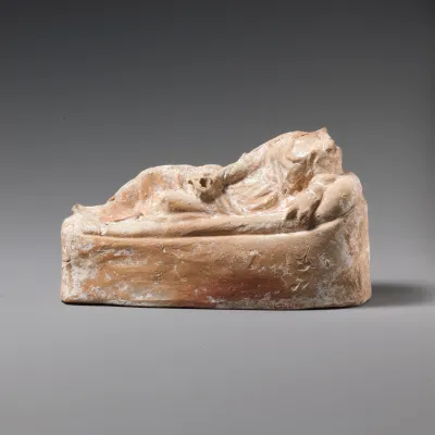 Terracotta statuette of a woman reclining on a couch