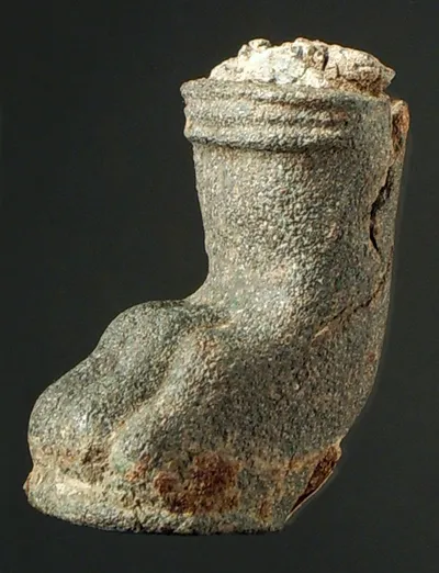 Löwenfuß, wohl von einem Dreifuß (Stabdreifuß), ungereinigt, Reste von Kernmasse und Blei(?)verguß, oben Reste der eisernen Stütze