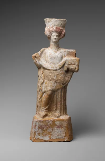 Terracotta statuette of a standing woman with a basket and wreath