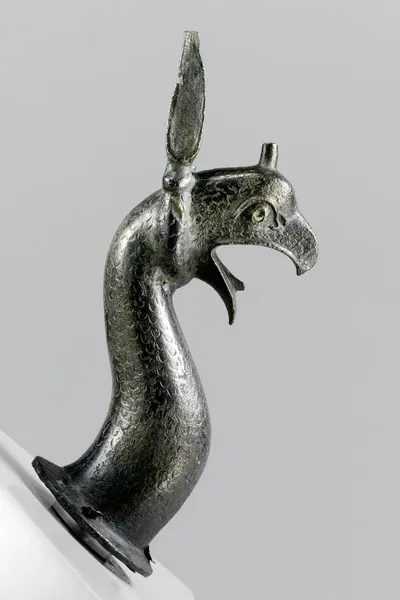 Greifenprotome, gegossen, reduziert, Knauf und linkes Ohr fragmentiert, im rechten Auge eingelegte Iris erhalten, mehrere kleine Gussfehler