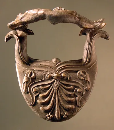 Etruskischer Henkel von einem runden Gefäß in Gestalt eines rückwärts liegenden nackten Jünglings, der die Rechte unter den Kopf legt, ...