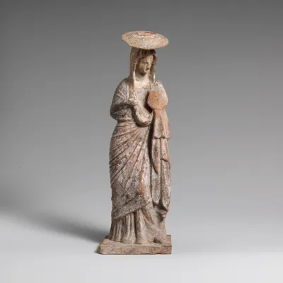 Terracotta statuette of a woman wearing a hat and holding a fan