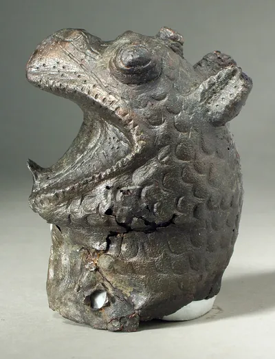 Greifenprotome, getrieben, rechte Halspartie verloren, mehrfache Risse im Blech, zwei kleine Nietlöcher und ein größeres gestanztes Loch am Rand, Füllmasse zum größten Teil erhalten, reduziert