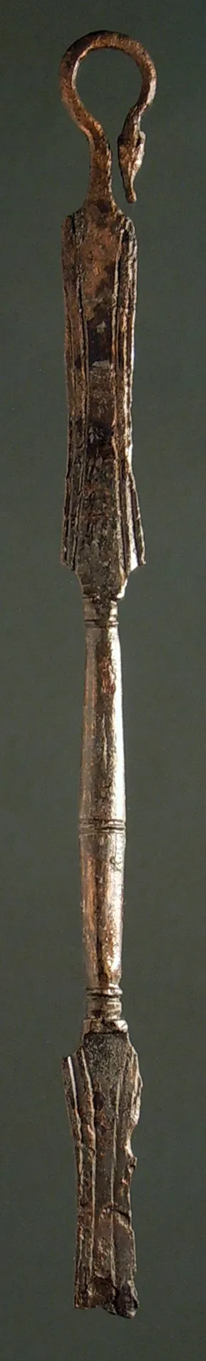 Griff einer Schöpfkelle, wie Misc. 10045, nur kleiner. Unten abgebrochen. Henkel endet oben in einem Hundekopf. Am Mittelstück keine Buckeln